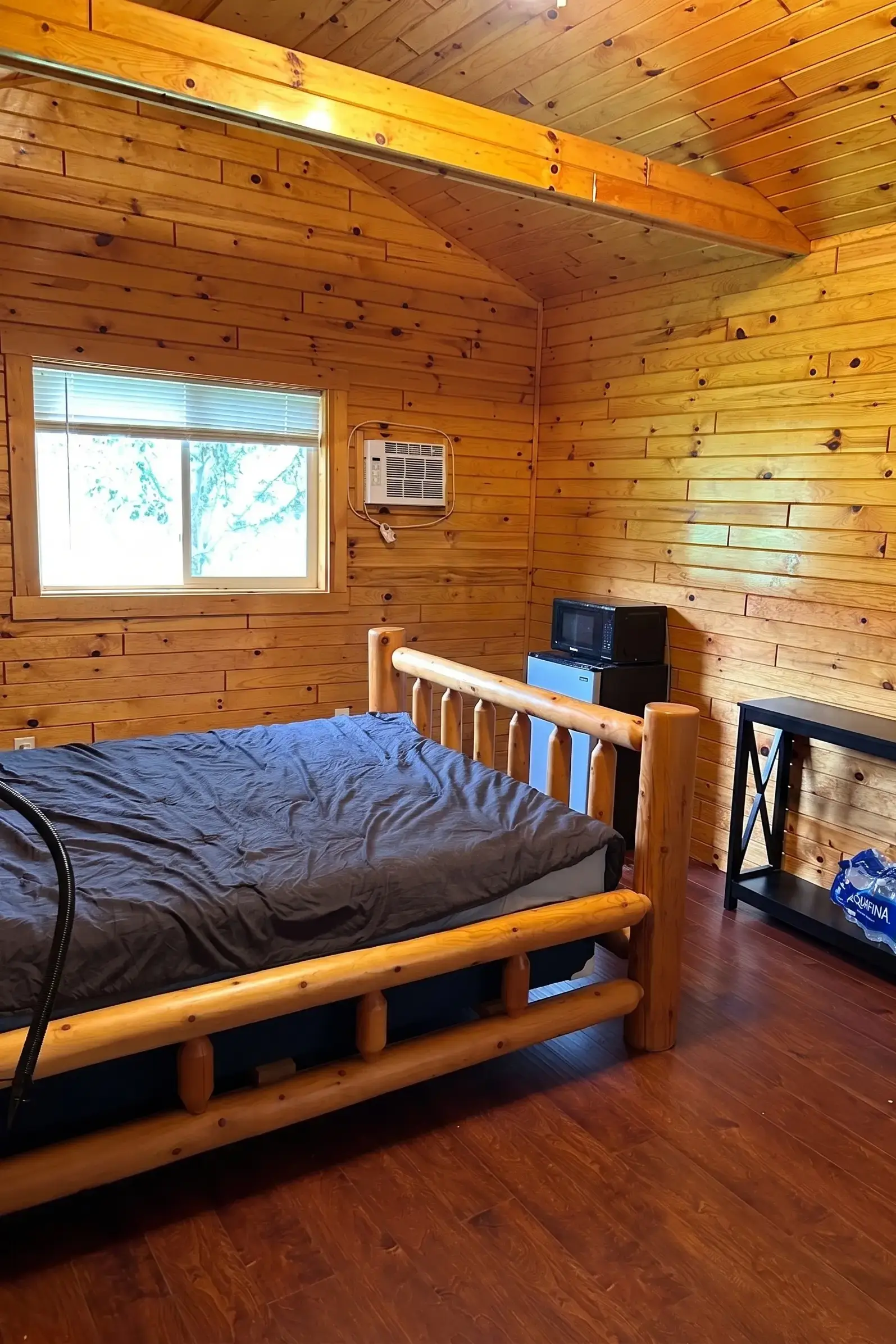 Cozy knotty pine cabin interior with bunk beds and A/C unit