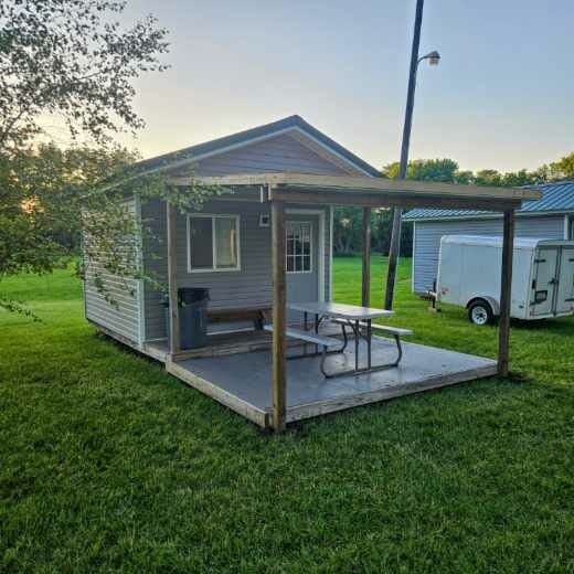 Camp Ziegenhorn cabin with covered porch and picnic table at dusk