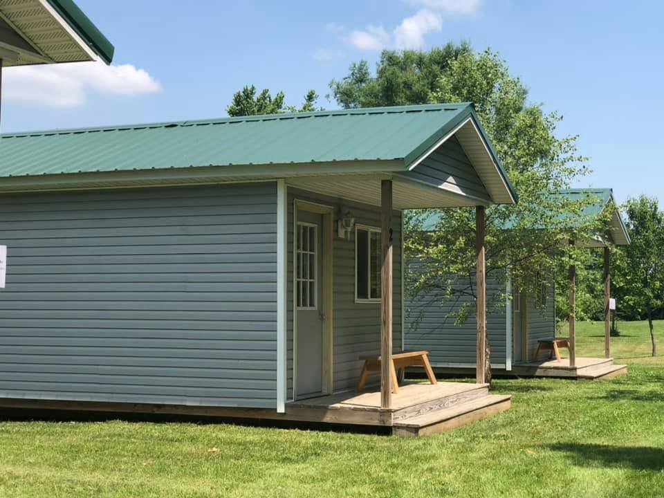 Row of Camp Ziegenhorn cabins with green metal roofs and covered porches